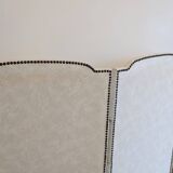 Vintage white faux leather screen with four studded panels, elegant decor.