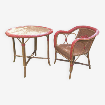 Rattan dining table and armchair. Old garden furniture from the beginning of the 20th century.