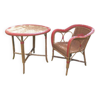 Rattan dining table and armchair. Old garden furniture from the beginning of the 20th century.