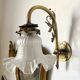 Antique brass wall light with glass shade.