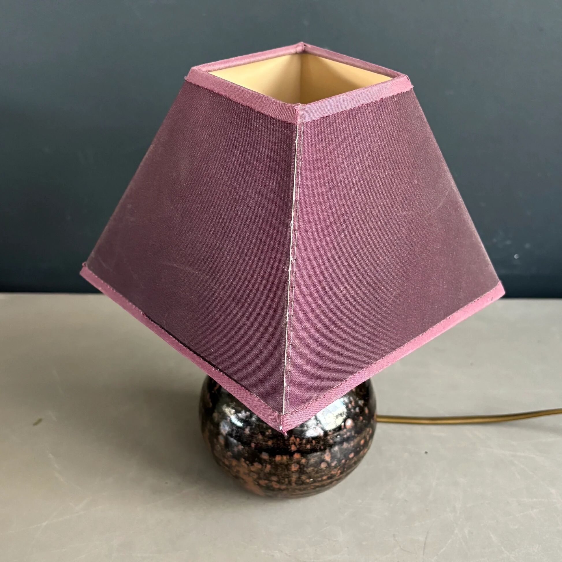 Ceramic floor lamp with a pyramidal shade and square base.