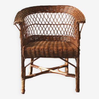 Woven rattan armchair with armrests.