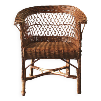 Woven rattan armchair with armrests.