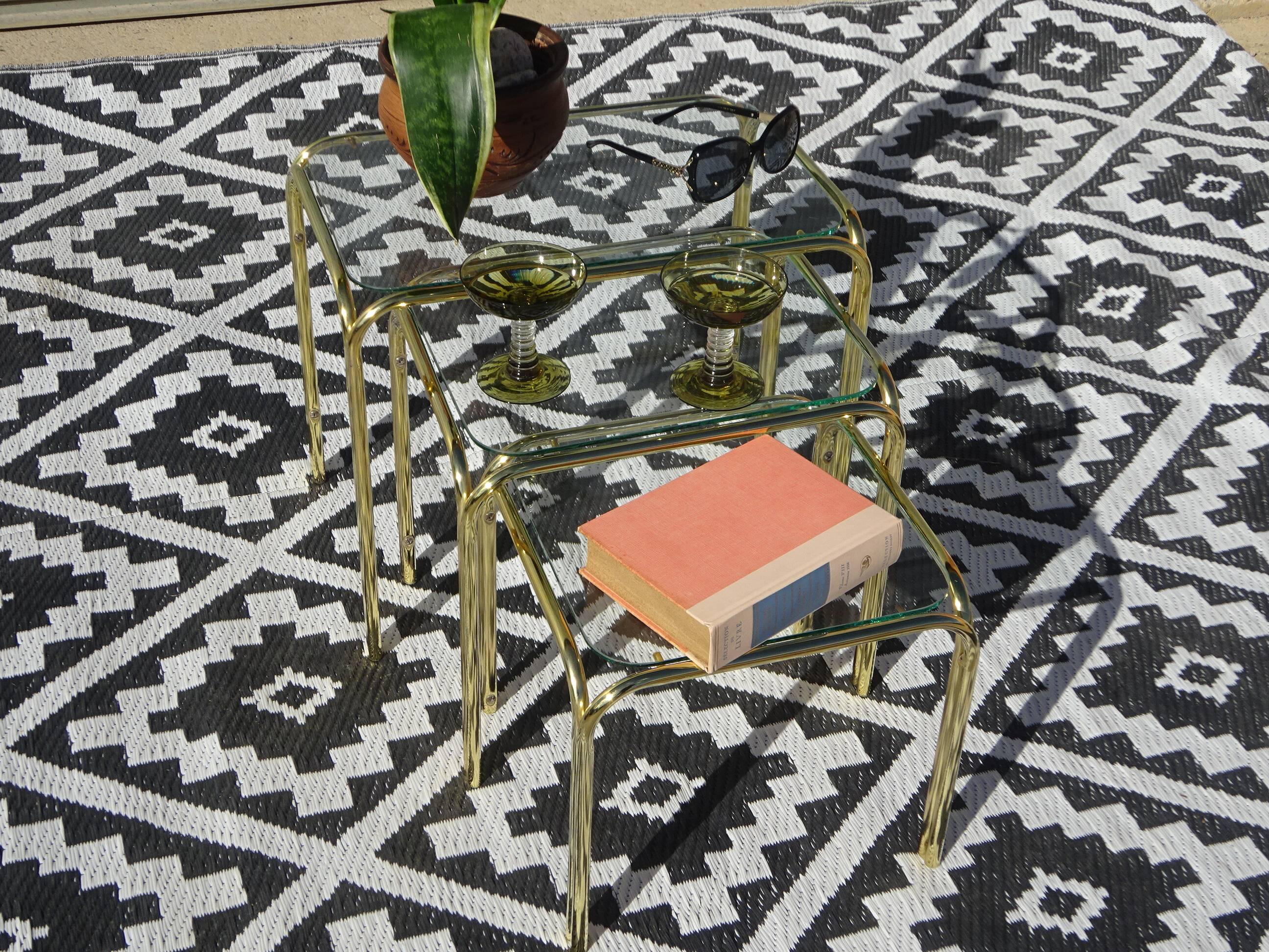 Nested tubular tables in gold metal.