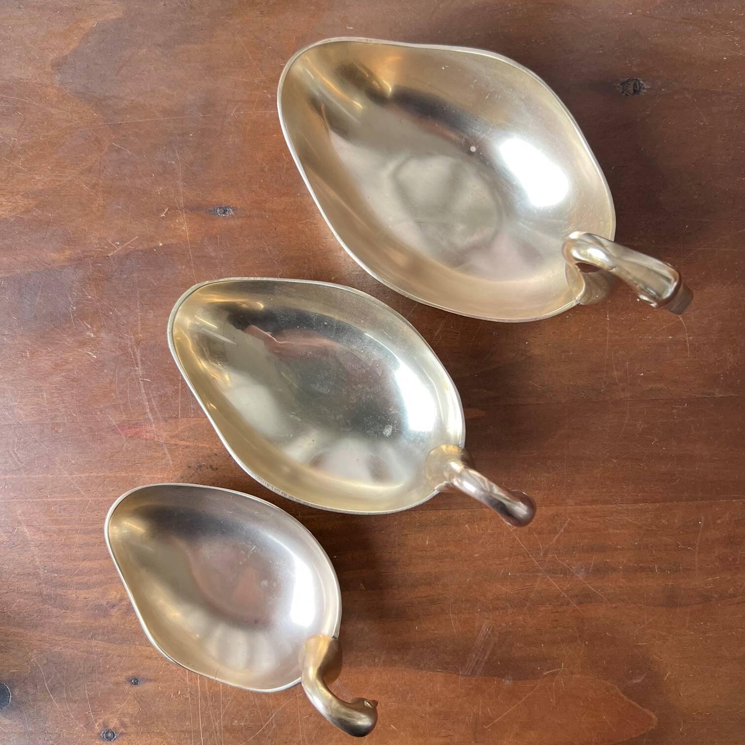 Trio of “swan” cups in gilded brass