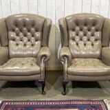Pair of high-backed Chesterfield armchairs with 1 leather footrest
