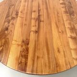 Modernist round table in solid elm, crossed legs.