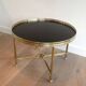 Round coffee table in brass with a black lacquered glass top by Maison Jansen.