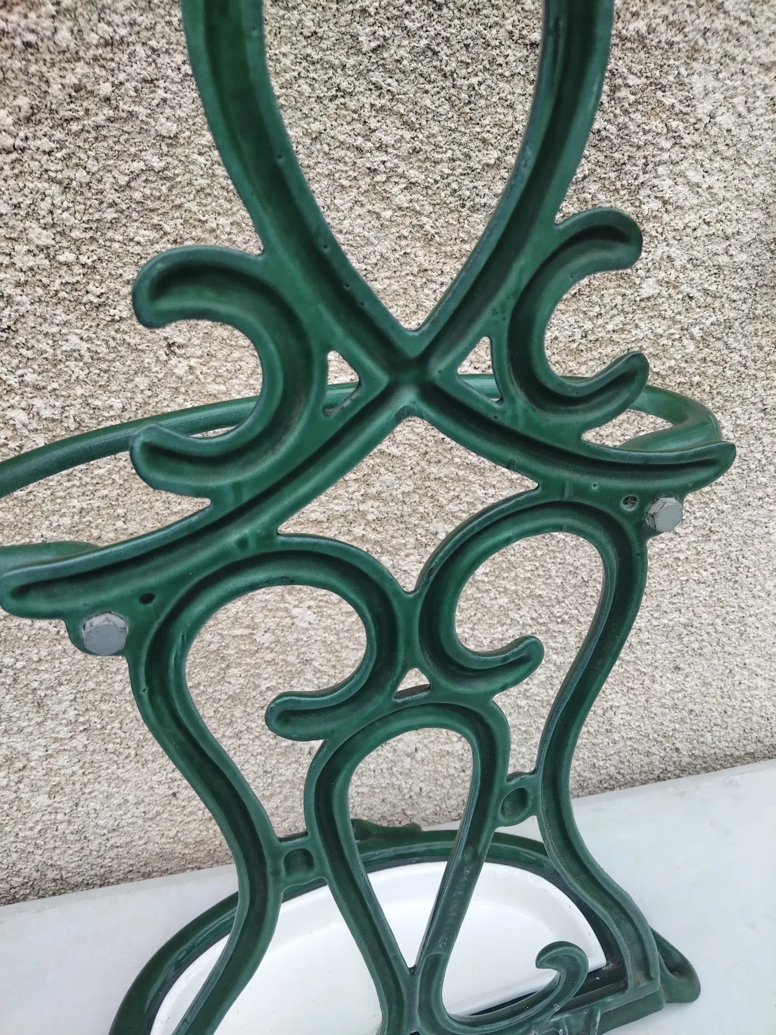 Bottle green enamelled cast iron umbrella stand with a swirl design.