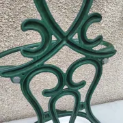 Bottle green enamelled cast iron umbrella stand with a swirl design.