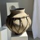 Very large light grey terracotta pot with handles and rattan crossbars.