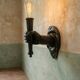 Wall lamp in iron shaped like an arm.