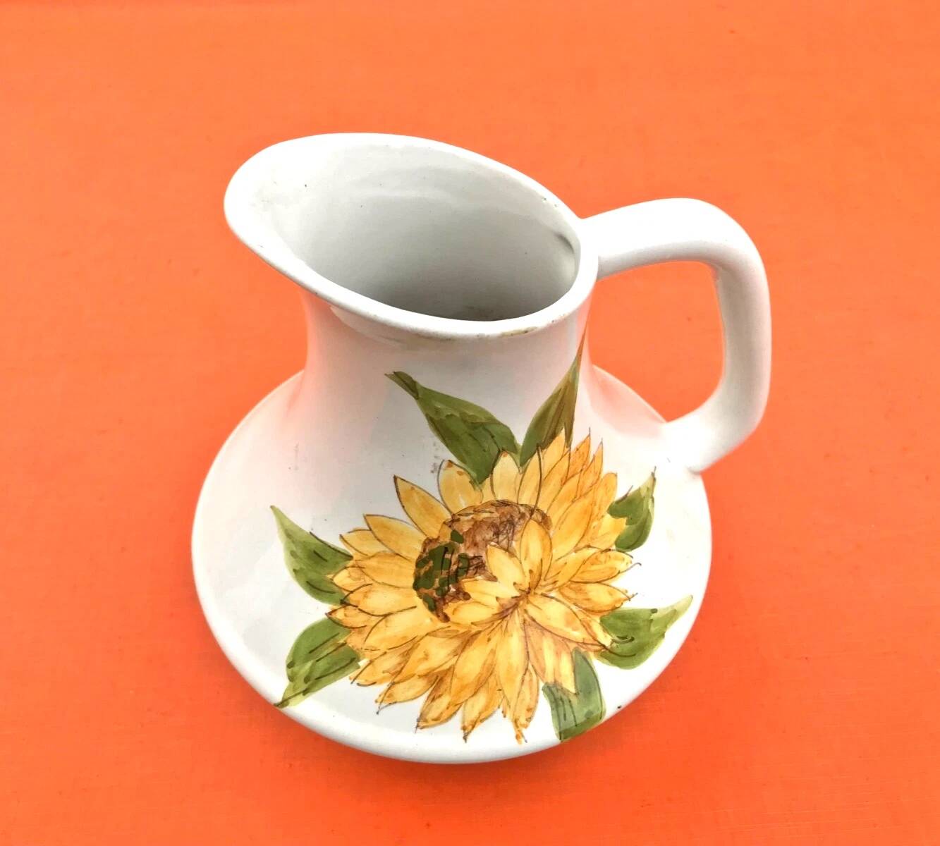 Antique glazed ceramic pitcher with sunflower decoration