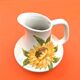 Antique glazed ceramic pitcher with sunflower decoration