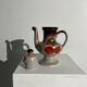 Vintage stoneware teapot with flower and fruit patterns