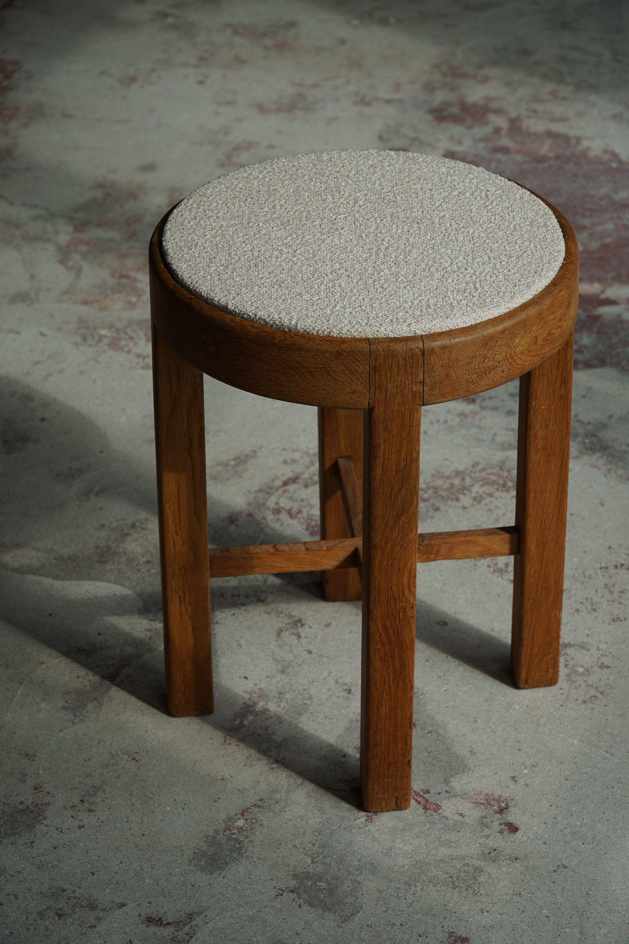 Mid-century Danish stool in oak, reupholstered in boucle wool, circa 1950.