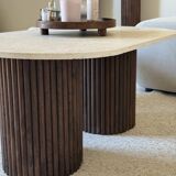Oval coffee table in travertine and fluted wood.