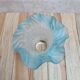 An antique lampshade in frosted glass with delicate blue edges.