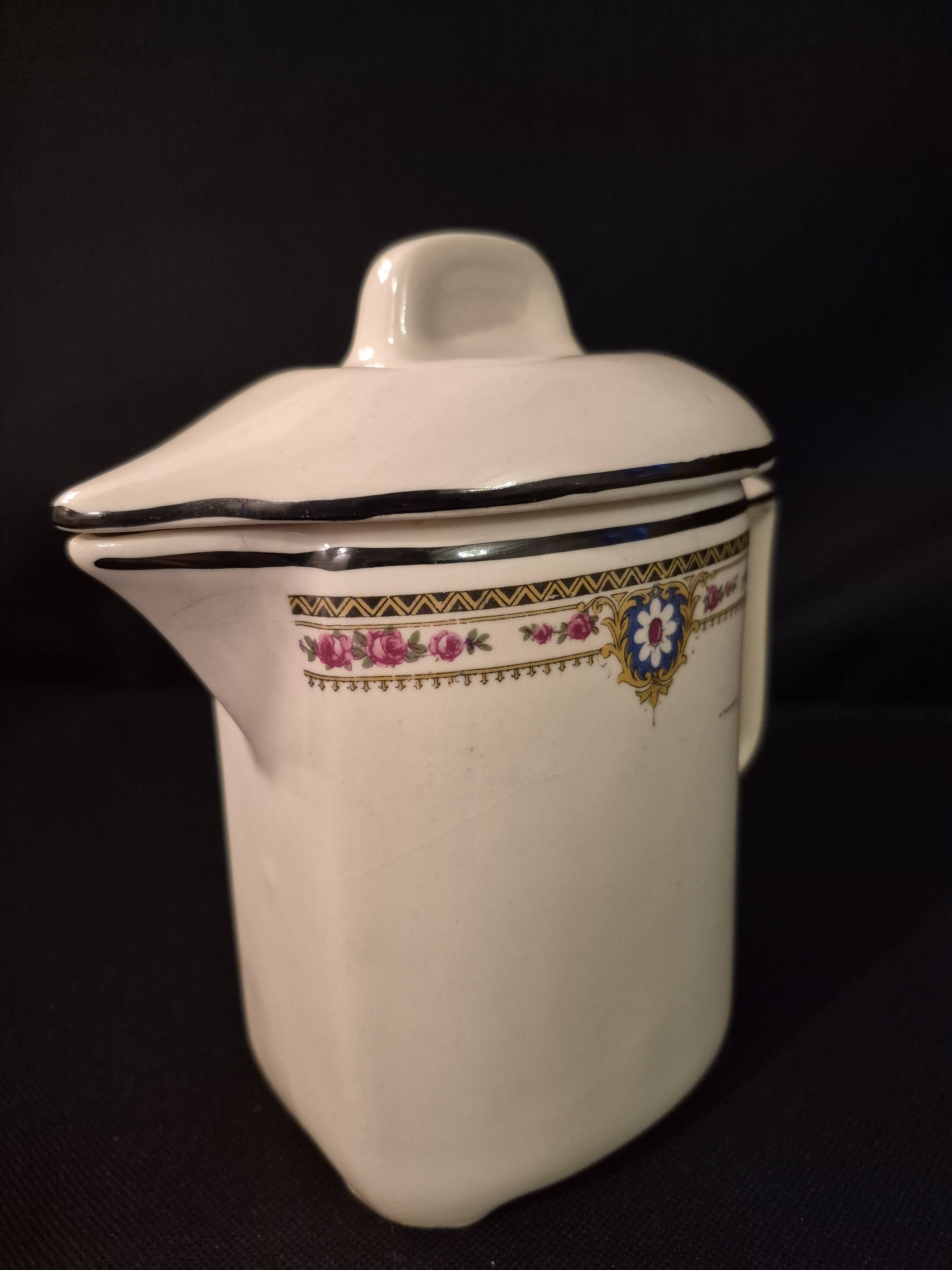 Old covered jug, vintage, geometric frieze with flowers and black trim.