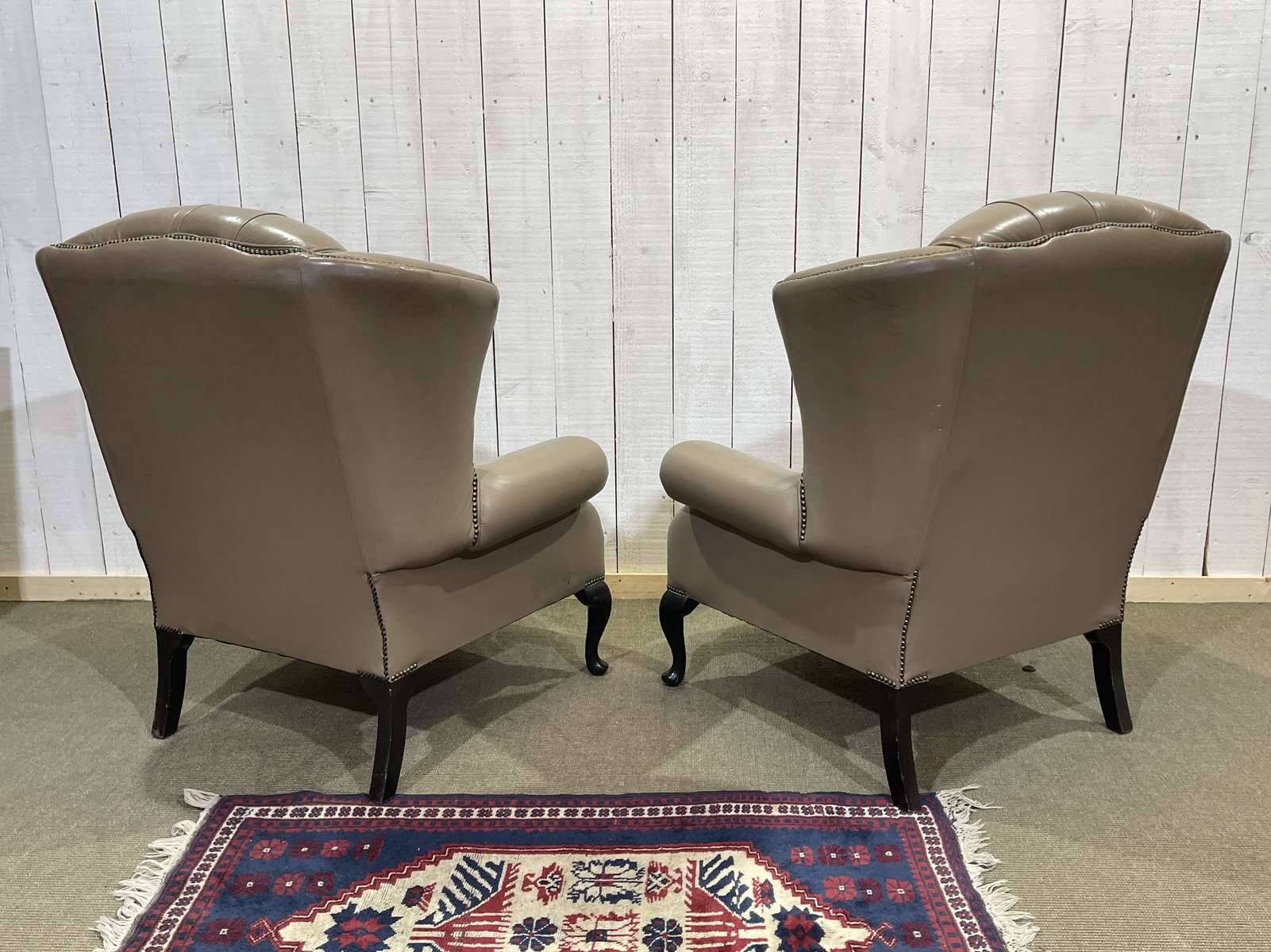 Pair of high-backed Chesterfield armchairs with 1 leather footrest
