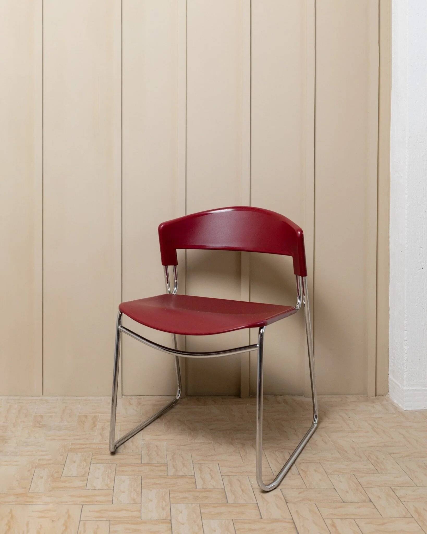 Red plastic-seat stacking chair with chrome frame by Paolo Favaretto for Assisa (Italy 1986) – vintage design