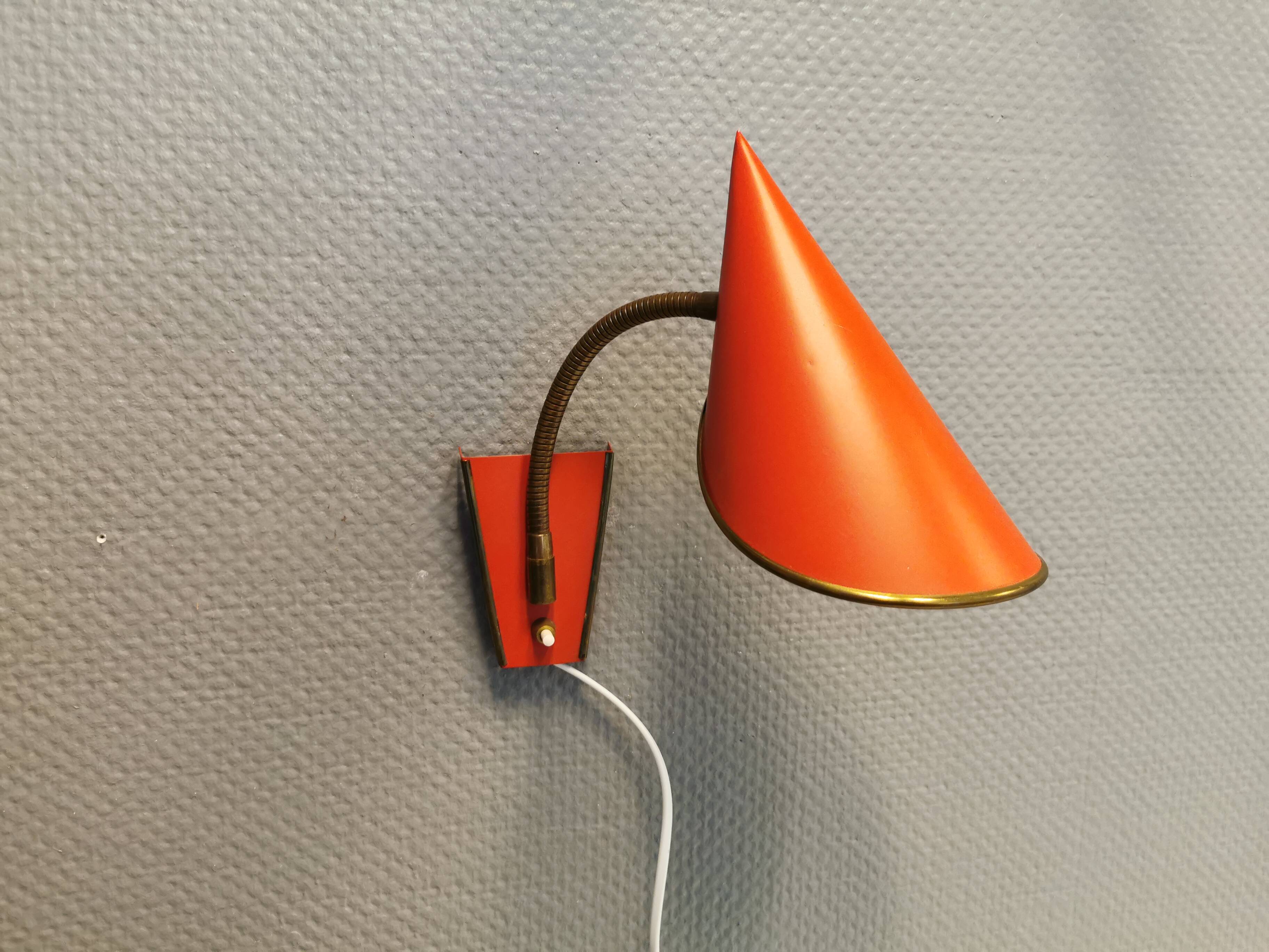 Danish red lacquered wall light with brass details. Estimated 1980s