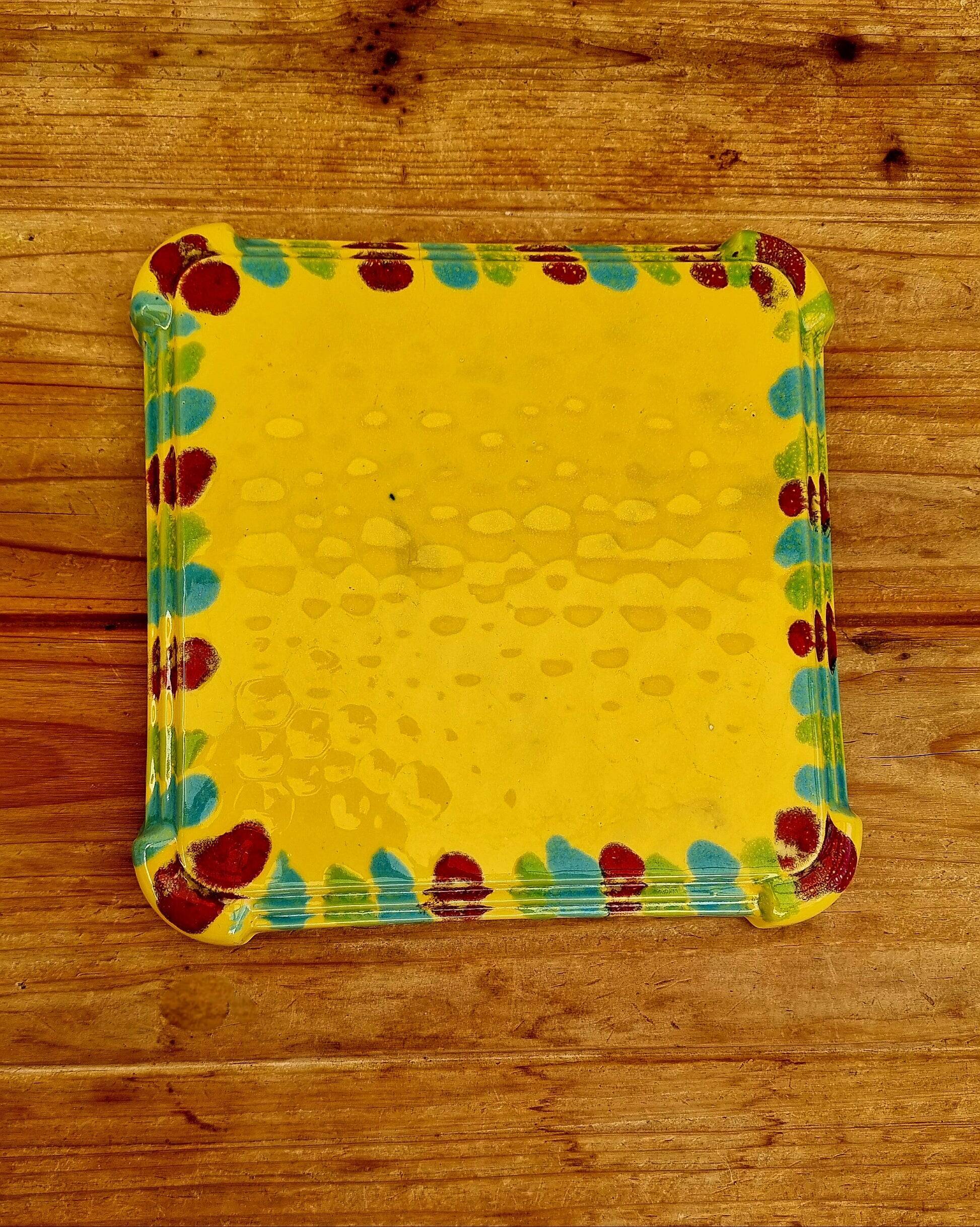 Yellow ceramic trivet and bottle coaster with vintage painted decoration.