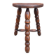 Low wooden tripod stool.