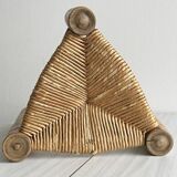 Antique tripod stool in light wood with a woven straw seat.