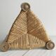 Antique tripod stool in light wood with a woven straw seat.