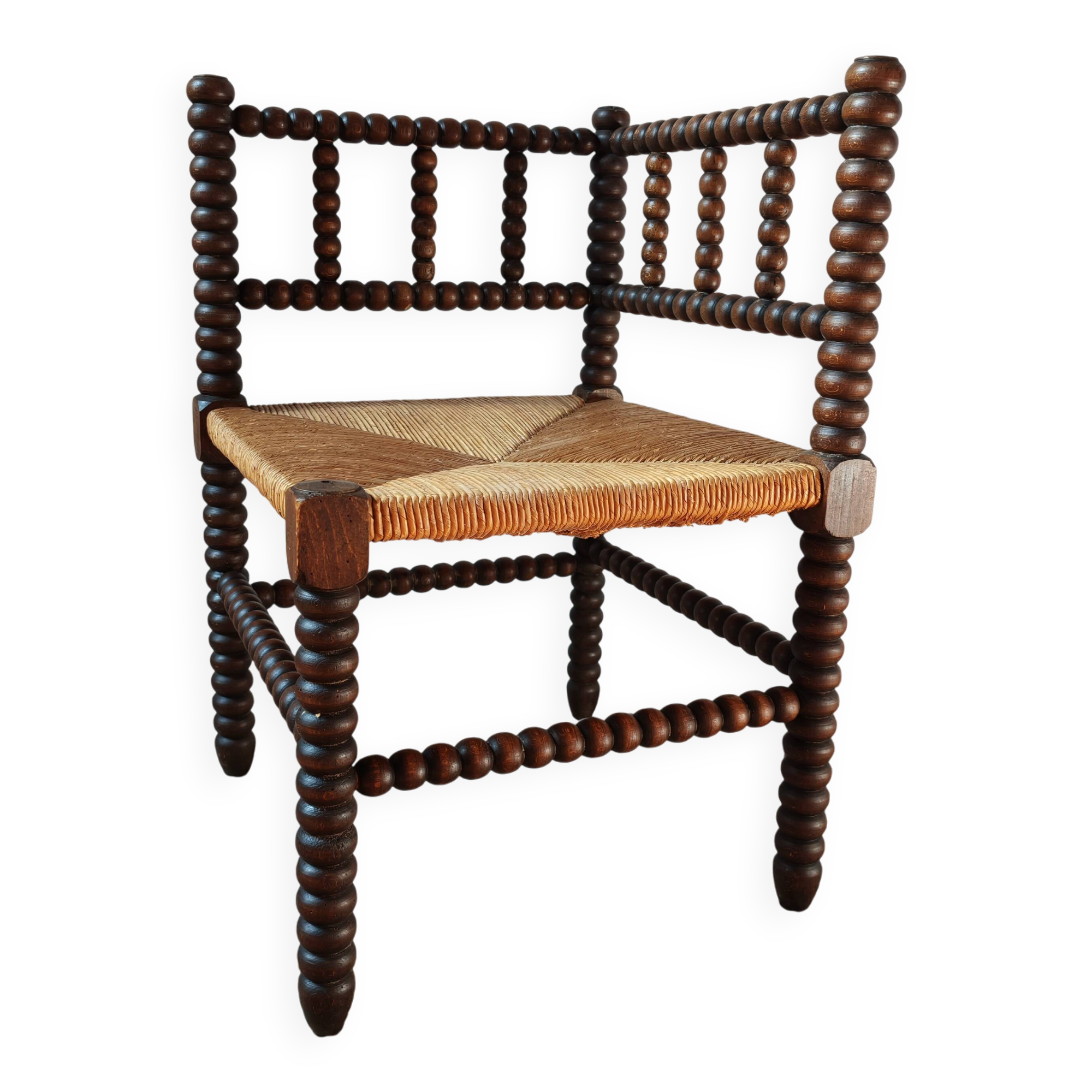 Old wooden turned spindle fireside chair with a straw seat.