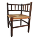 Old wooden turned spindle fireside chair with a straw seat.