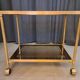 Serving cart in gilded brass and tinted glass