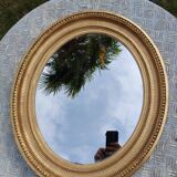 Antique oval mirror in gilded stucco with gold leaf, 19th century