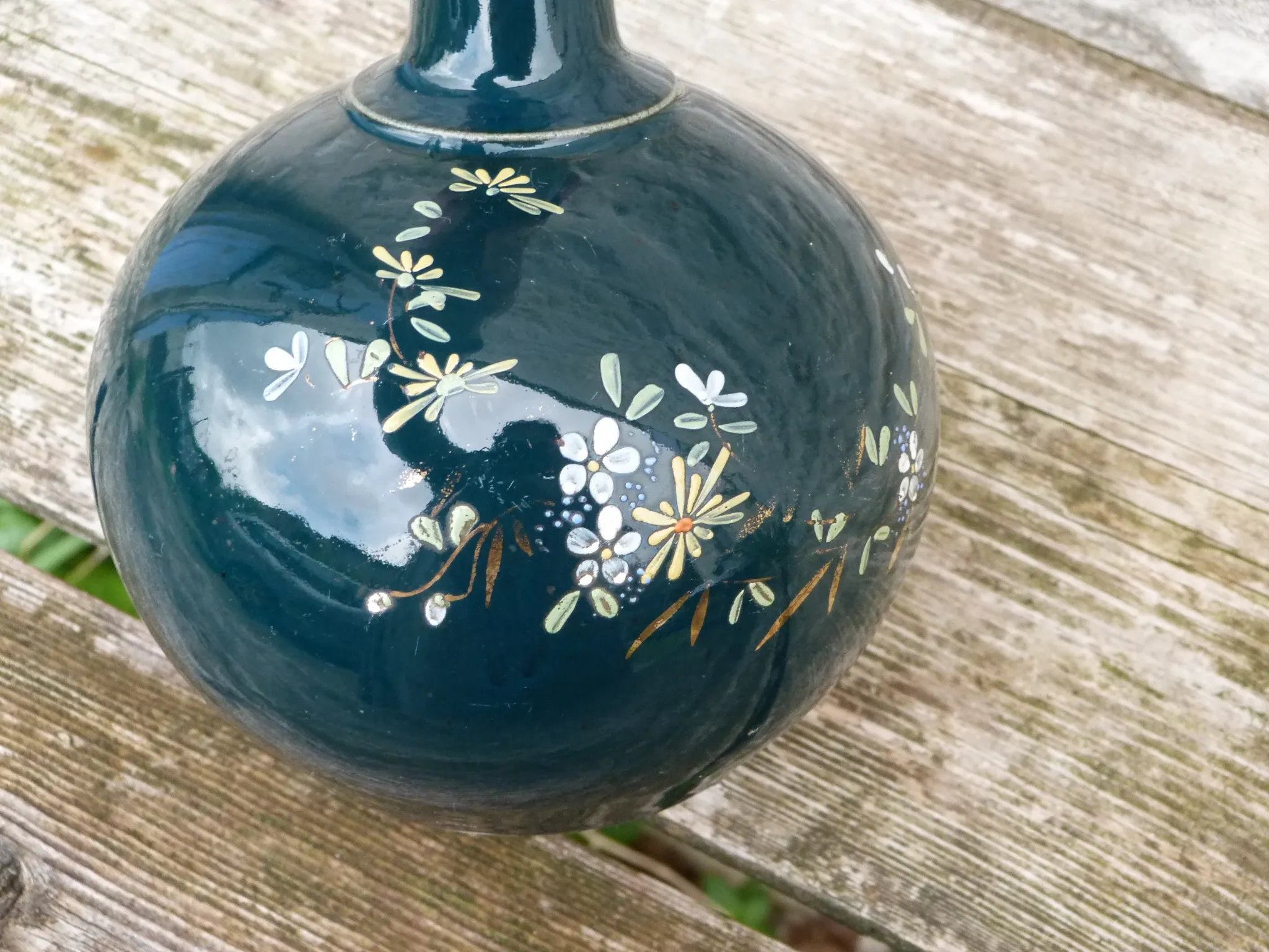 Old ceramic jug with flowers or single-stem vase.