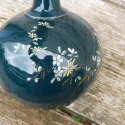 Old ceramic jug with flowers or single-stem vase.