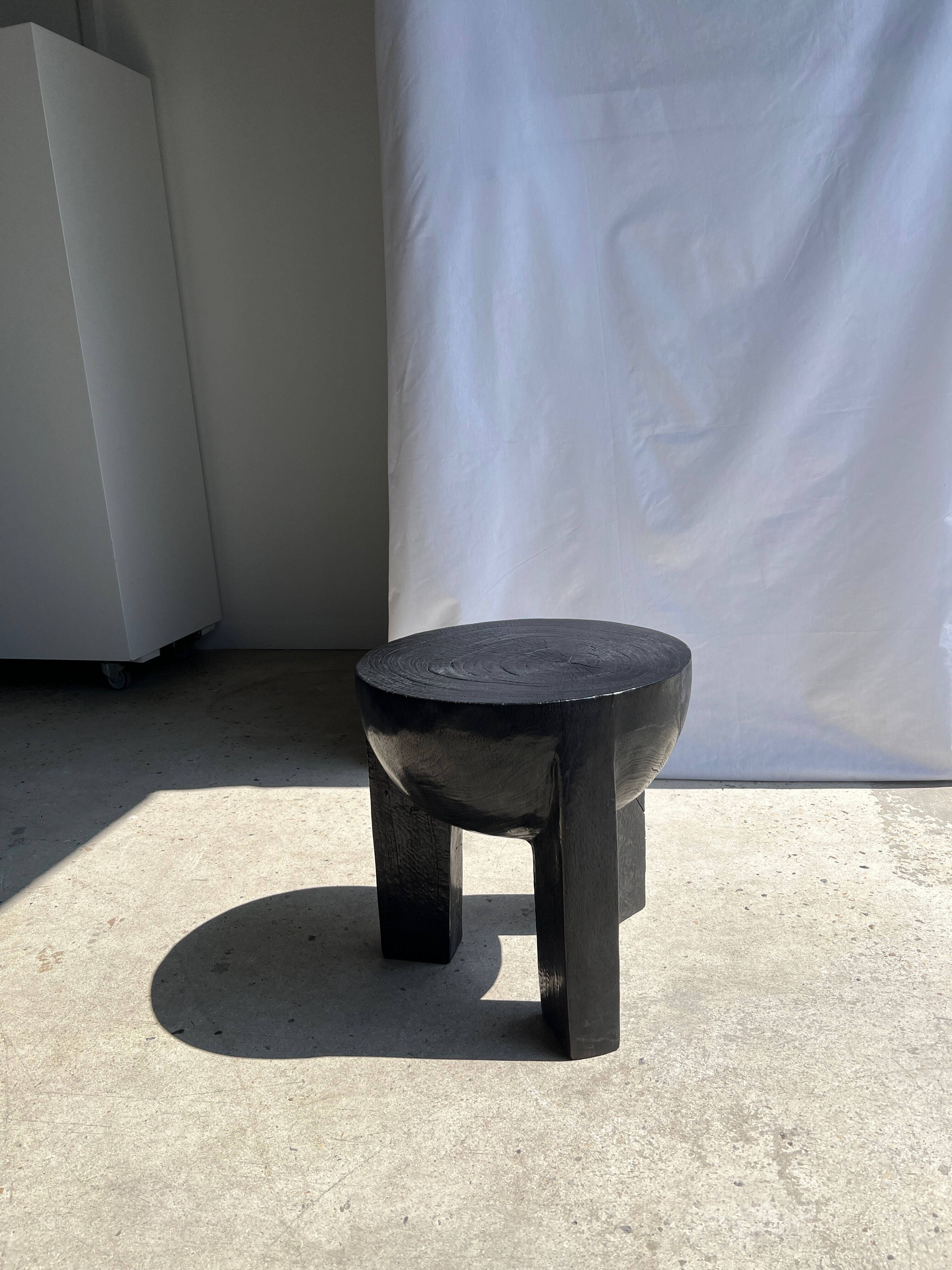 Black mango wood tripod side table with a semi-spherical top, height: 45 cm, diameter: 44 cm.