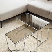 Set of 2 vintage nesting coffee tables in chrome metal and smoked glass.