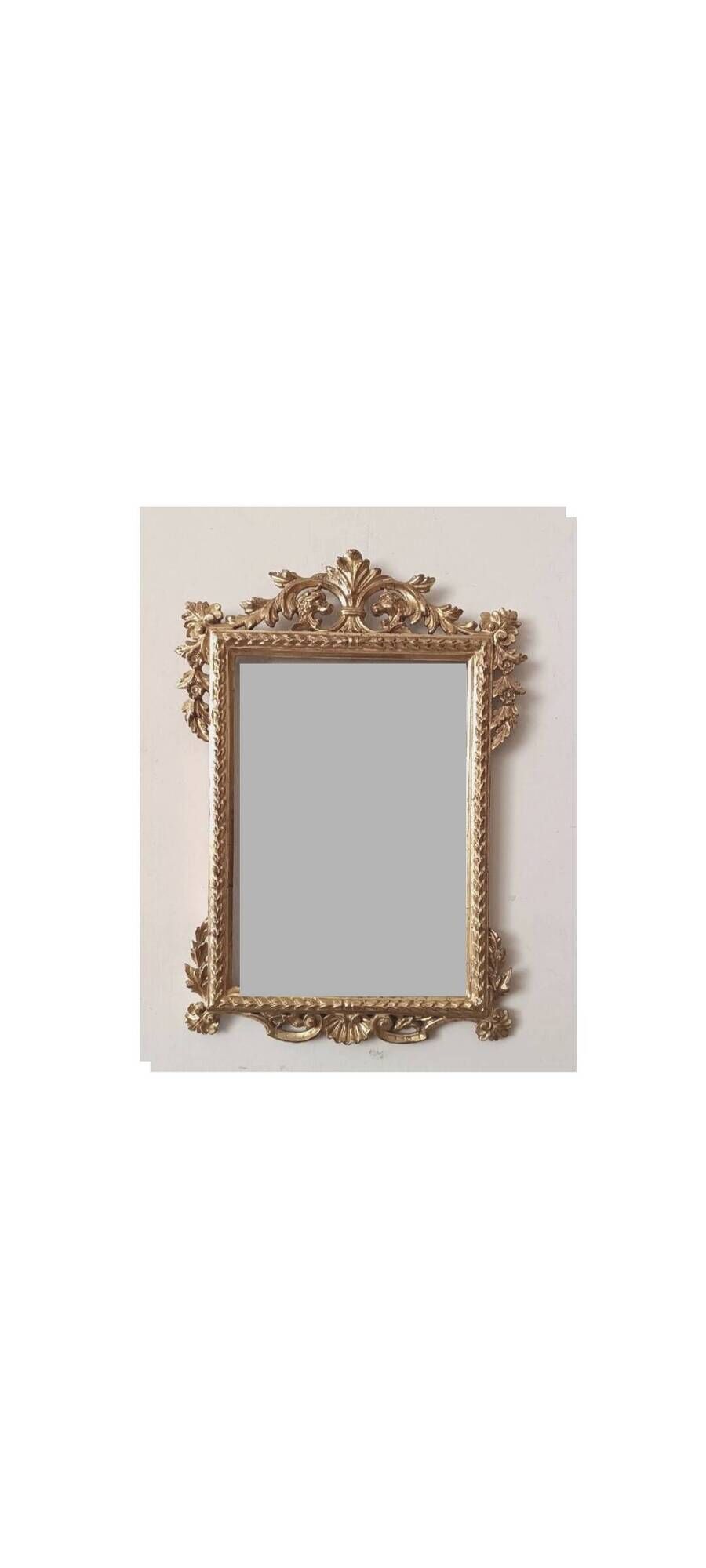 Mirror with a carved wooden frame in an antique style in pure gold.