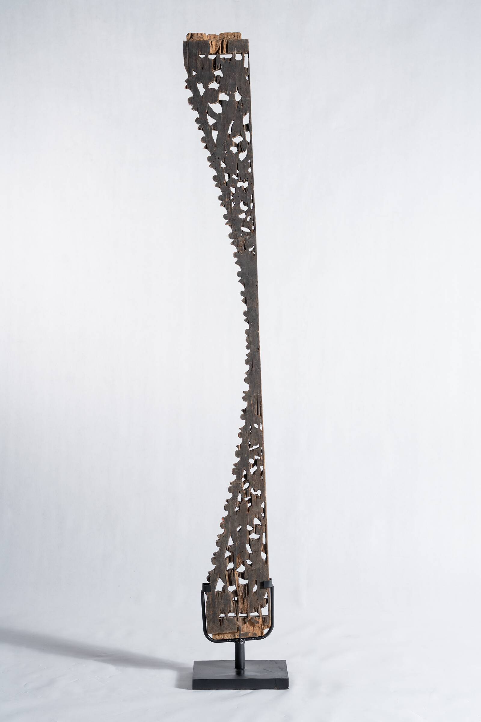 Indonesian construction element in carved wood with intertwined plant motifs mounted on a base (fri