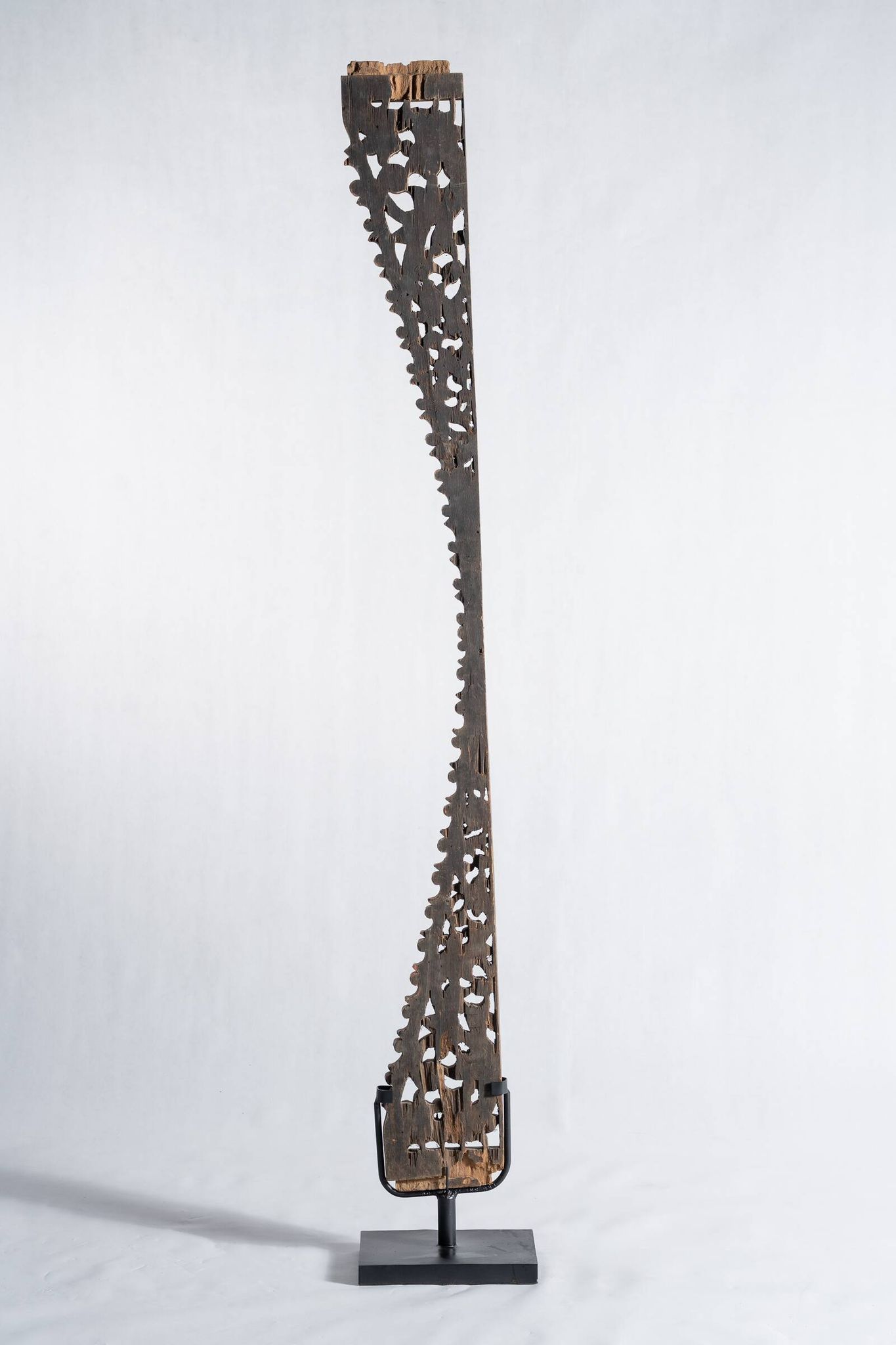 Indonesian construction element in carved wood with intertwined plant motifs mounted on a base (fri