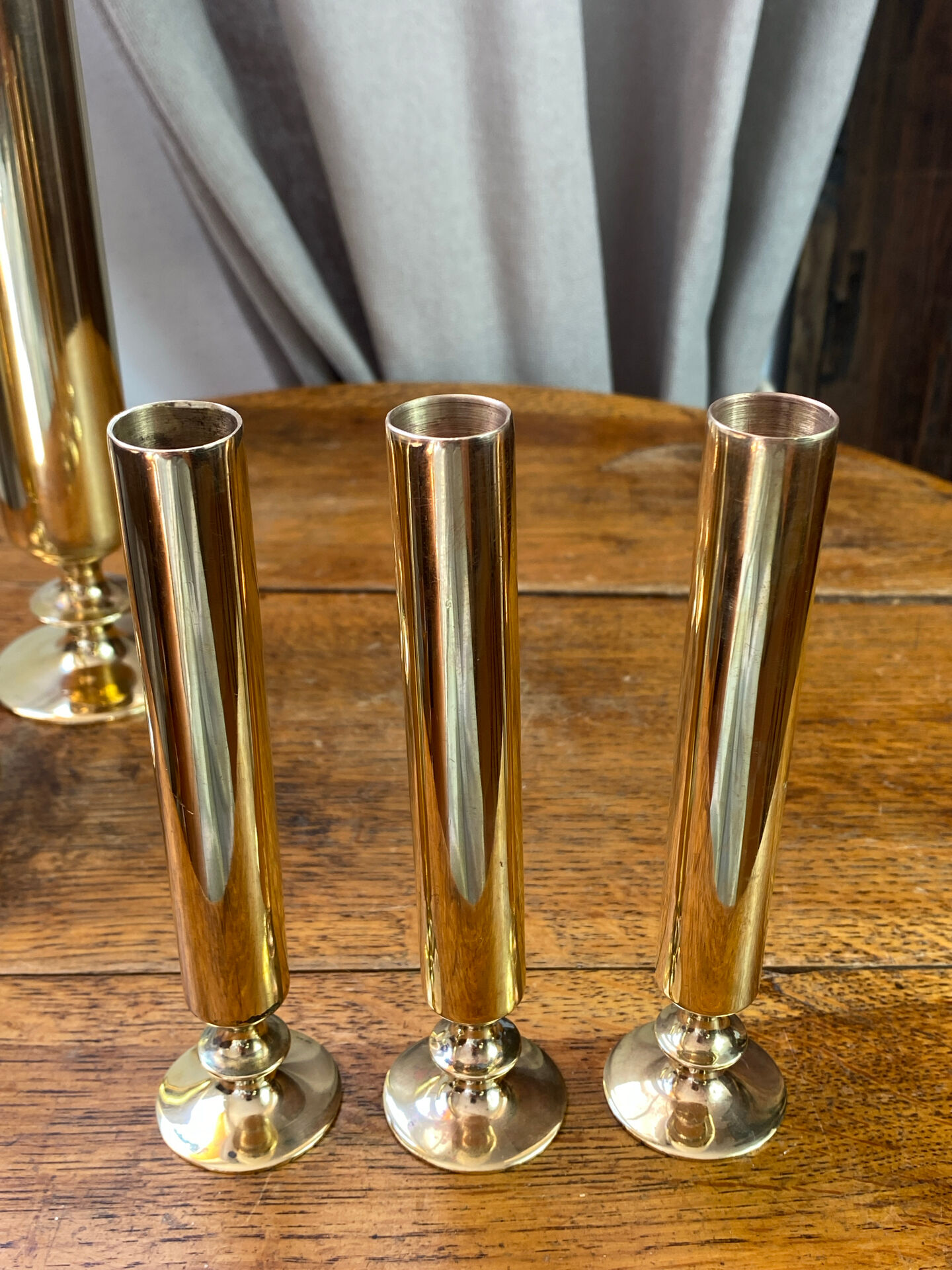 Set of candlesticks and tubular vases in solid brass.