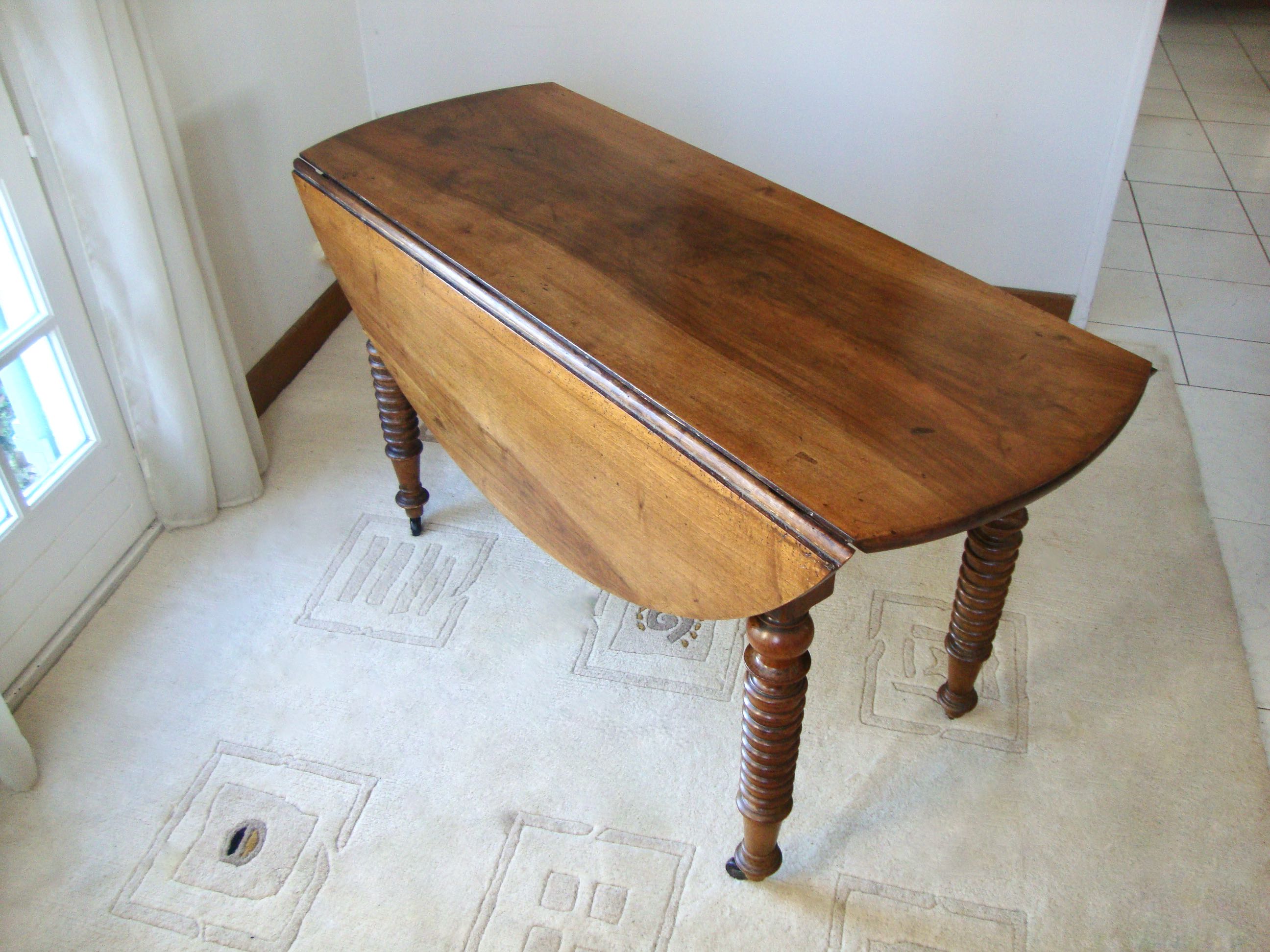 Mid-19th-century walnut round table with shutters, flaps