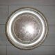 Large silver metal tray raised by a central foot