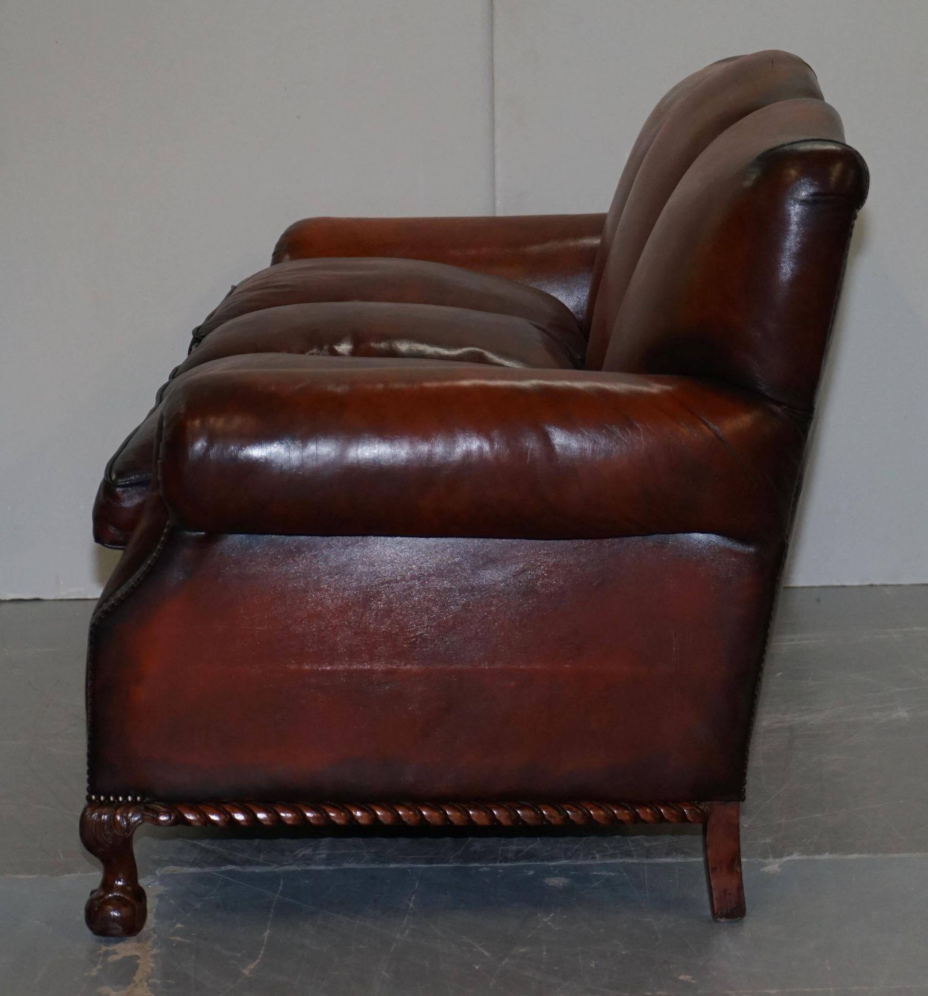 Restored Victorian sofa in leather with claw feet and feather cushions.