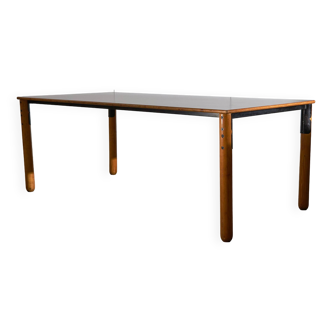 Grande table en bois avec plateau de couleur mate et éléments en métal