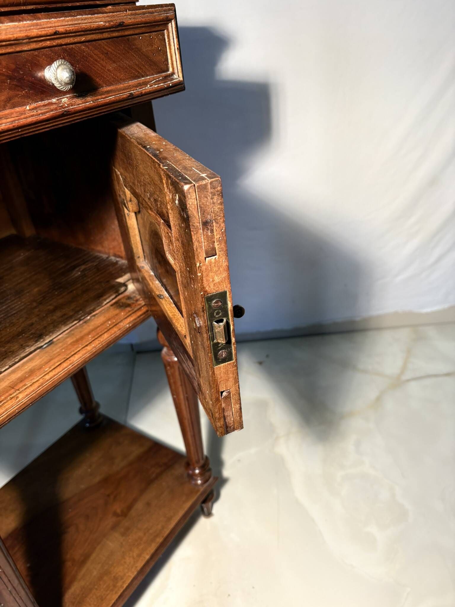 Antique wooden bedside table with turned legs.