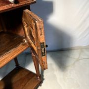 Antique wooden bedside table with turned legs.