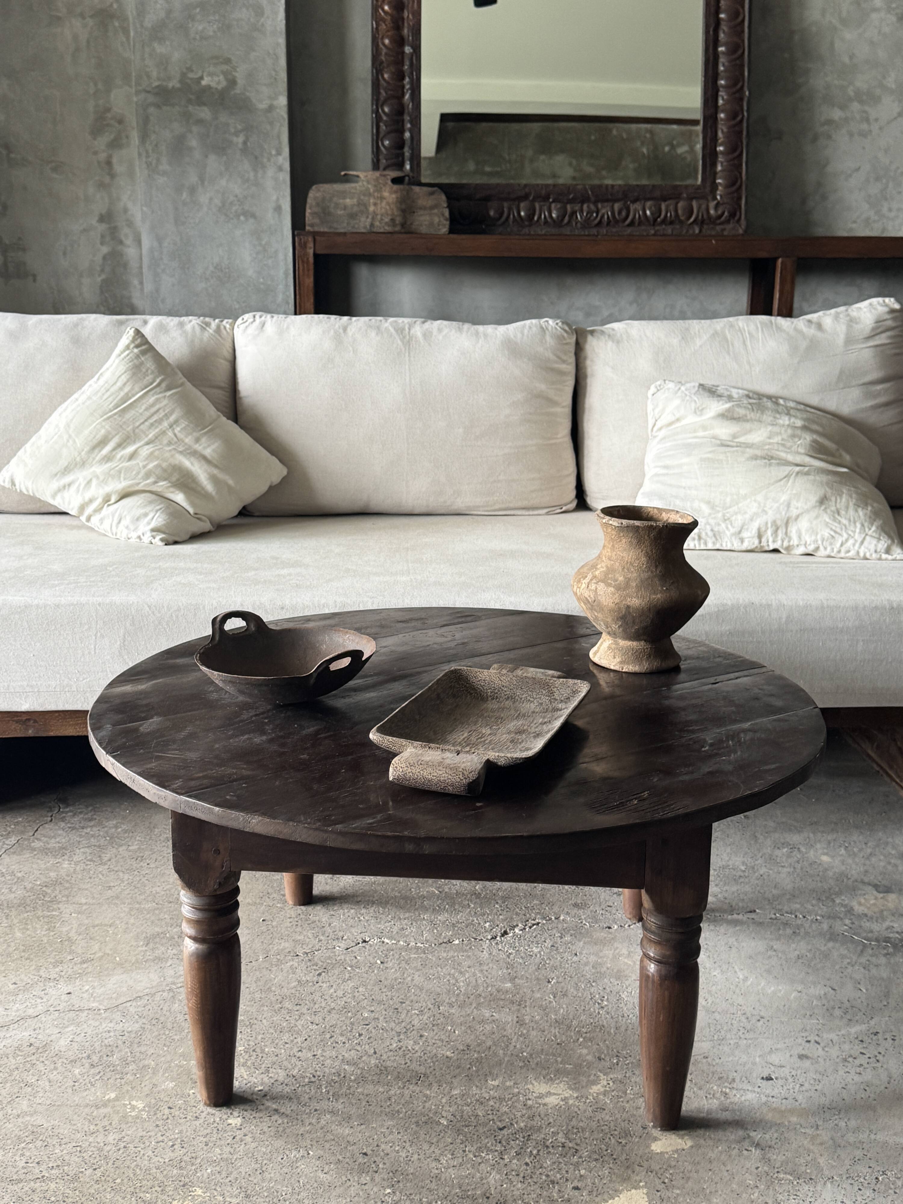Coffee table, round antique Indonesian teak table with straight legs.
