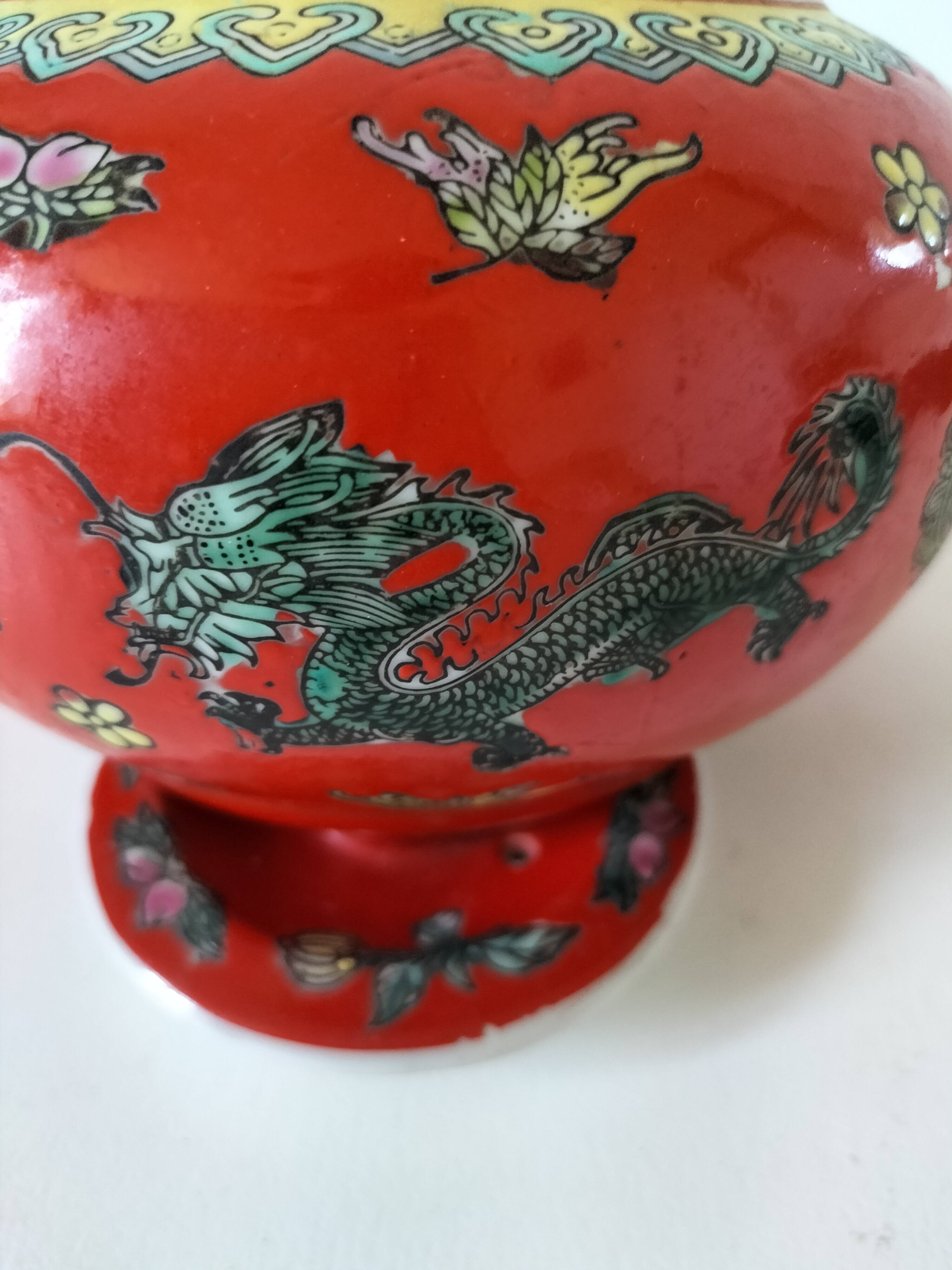 Vintage red Chinese teapot decorated with dragons and symbols.